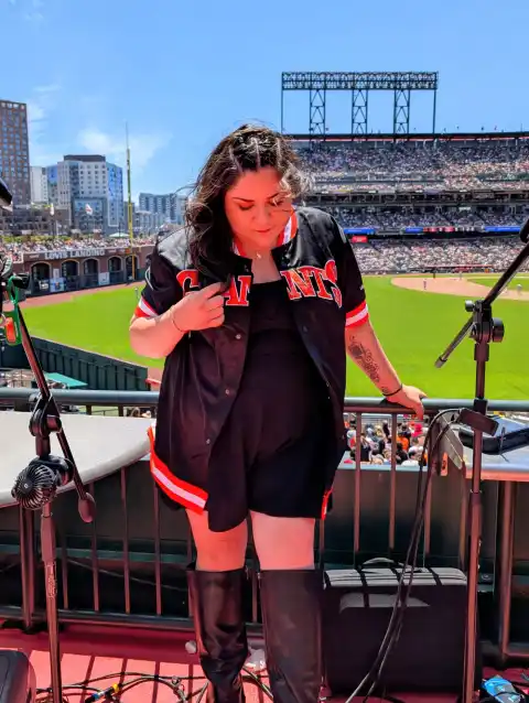 Laura Bravo adjusting her Giants jersey on stage at Oracle Park